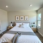 bedroom with a bed and three framed botanical prints.