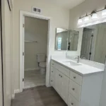 bathroom with a double-sink vanity and white cabinets