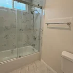 bathroom in California featuring a marble-patterned wall and floor