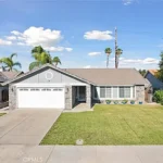 Real estate house with a gray exterior, large front lawn, and two-car garage