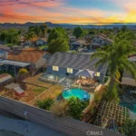 Aerial view of a backyard with a pool and patio covered