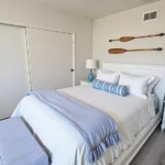 Bedroom with a white bed and blue pillows in California